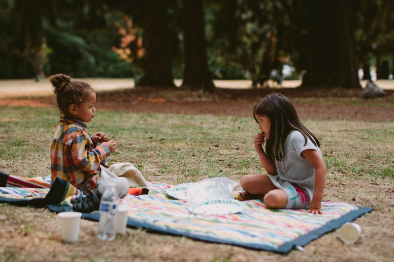 Kids on a picnic blanket at Lincoln Park in West Seattle.