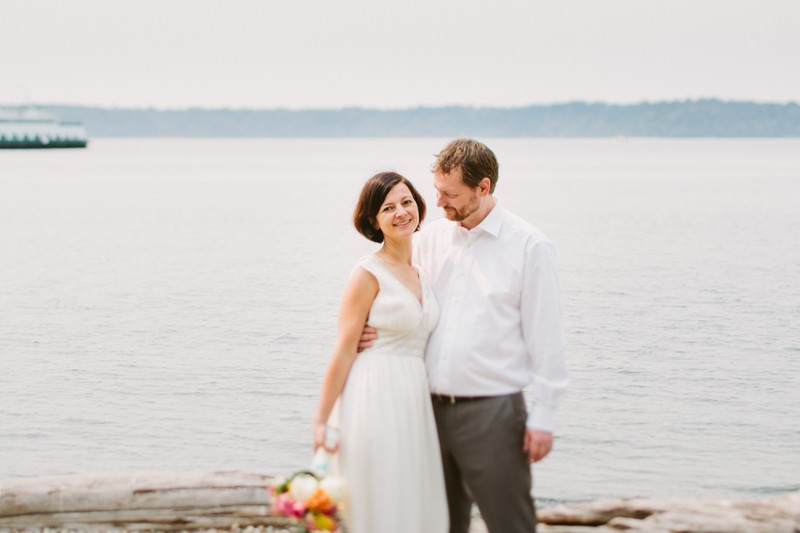 Seattle bride and groom smiling, with a ferry boat in the background.