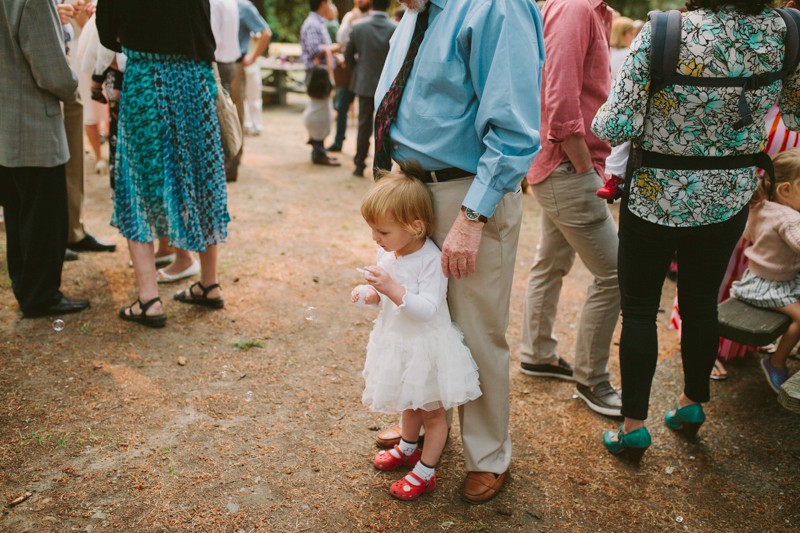 Bride and groom's daughter blows bubbles. 