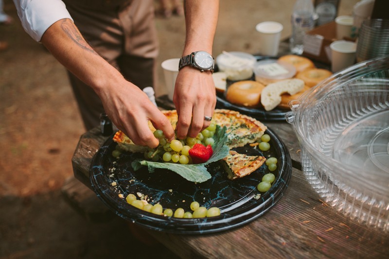 Picnic-style wedding food, with grapes, bagels and quiche. 