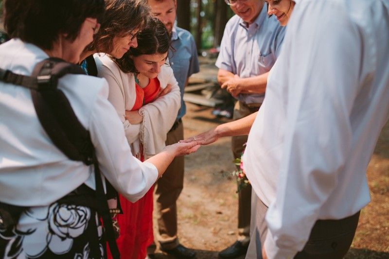 Guests admiring bride's wedding and engagement rings. 