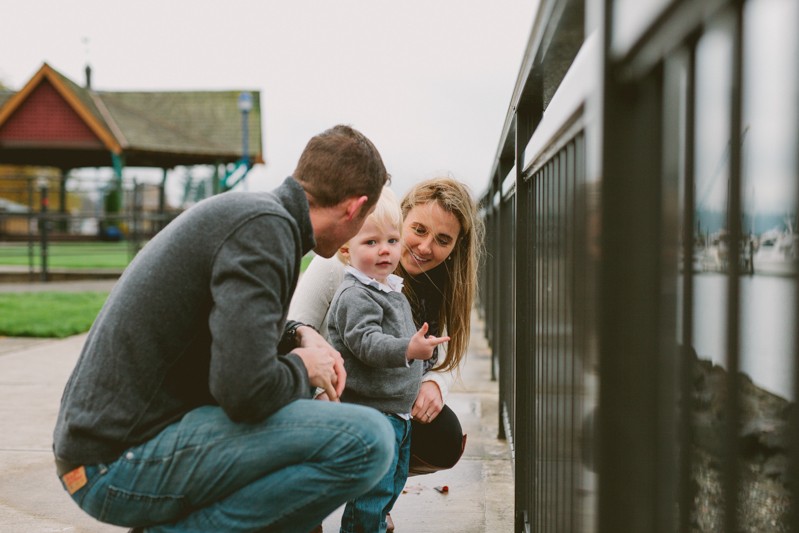 Lifestyle family photo session, with toddler pointing at the water, in scenic Poulsbo, Washington. 