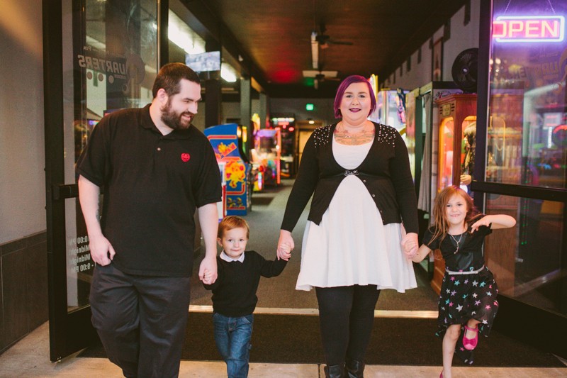 Non-traditional family at Quarters Arcade, holding hands and having fun. 