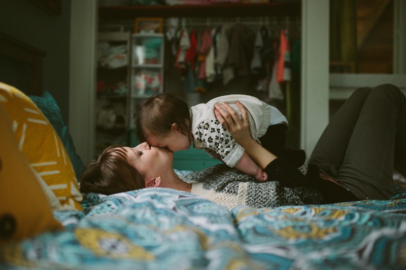 Mom kissing baby's forehead during a lifestyle portrait session in Bainbridge Island, WA. 