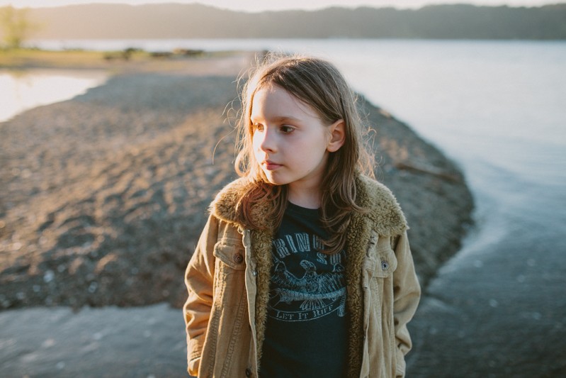 Boy standing along the water at Twanoh State Park at sunset.