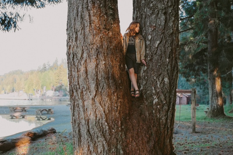 Boy standing in a tree at Twanoh State Park at sunset.