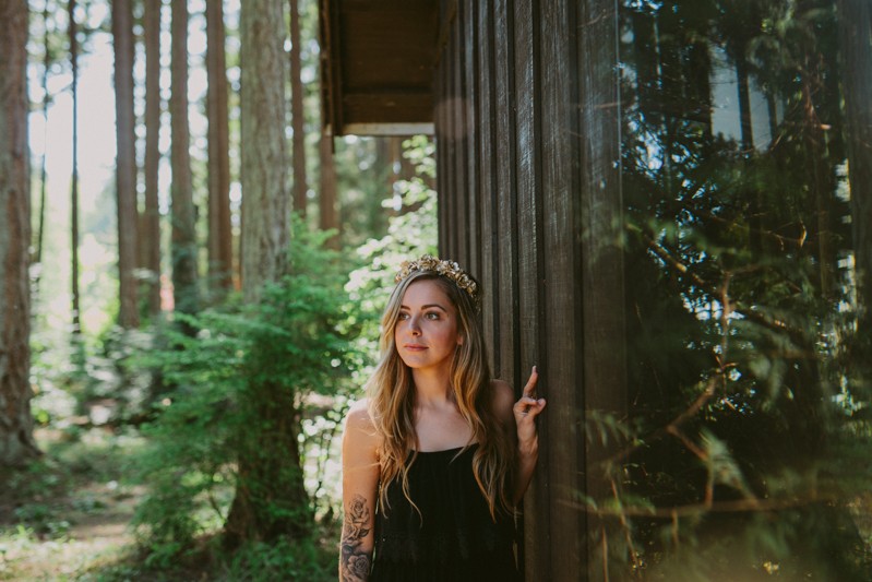 Tattooed model with long hair and a golden flower crown,