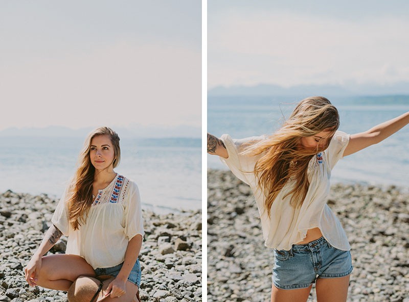 Model with boho style on a rocky beach, in a peasant top, with long hair.