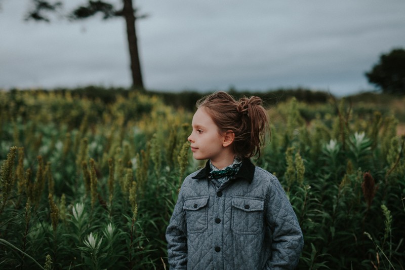 Lifestyle portrait with little boy wearing a bow tie and long hair in Port Townsend, WA.