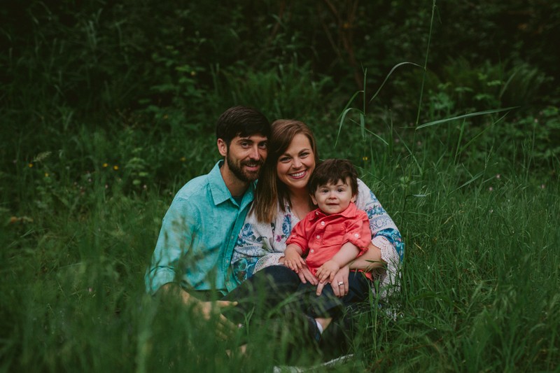 Family in brightly colored shirts, sitting in long grass, in Silverdale, WA.