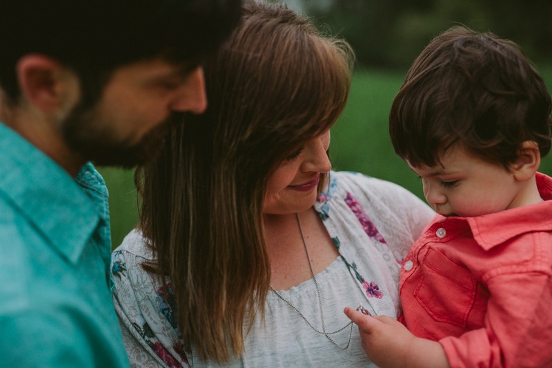 Toddler cuddling his parents.