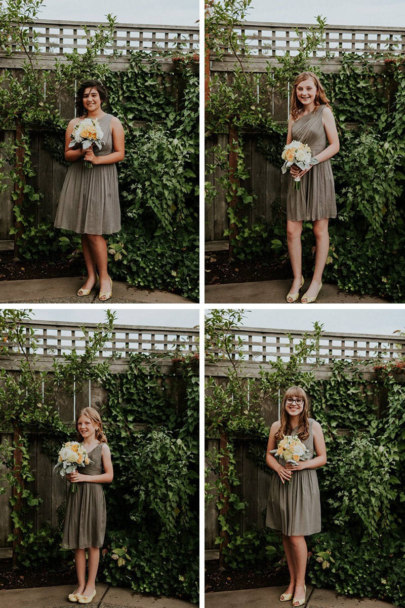 Junior bridesmaids in grey knee-length dresses, with white and yellow bouquets.