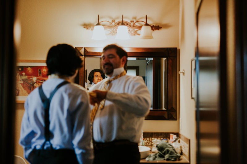 Groom and his son getting ready, with suspenders and ties.