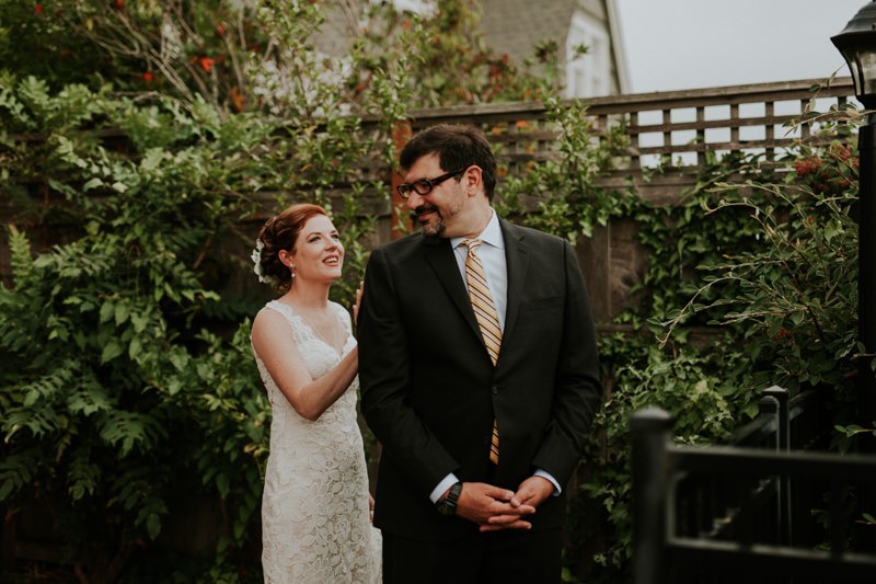 First look with bride in a sweetheart neckline gown, and groom in a black suit with a yellow tie.