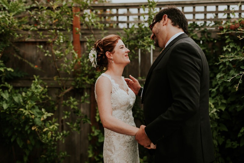 Sweet first look moment, with bride in a sleeveless dress and classic up-do.