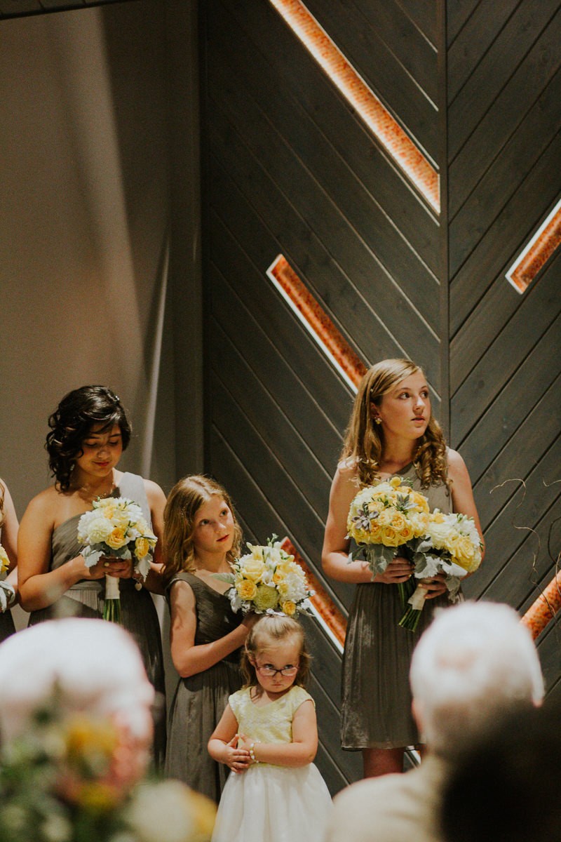 Junior bridesmaids and flower girls watch intently as the bride and groom exchange vows.