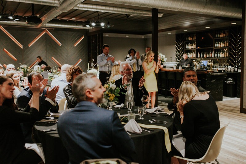 Guests clap and celebrate as bride and groom re-enter the reception.