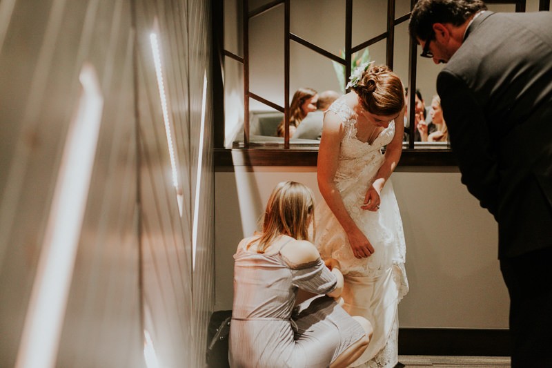 Bride's sister helps bustle her sweetheart neckline gown during the reception.