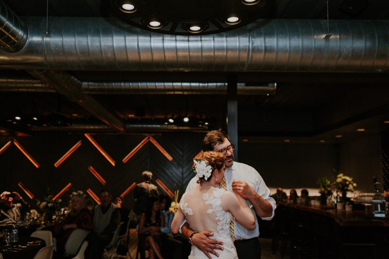 Sweet first dance moment, with bride in a gorgeous illusion-back dress.
