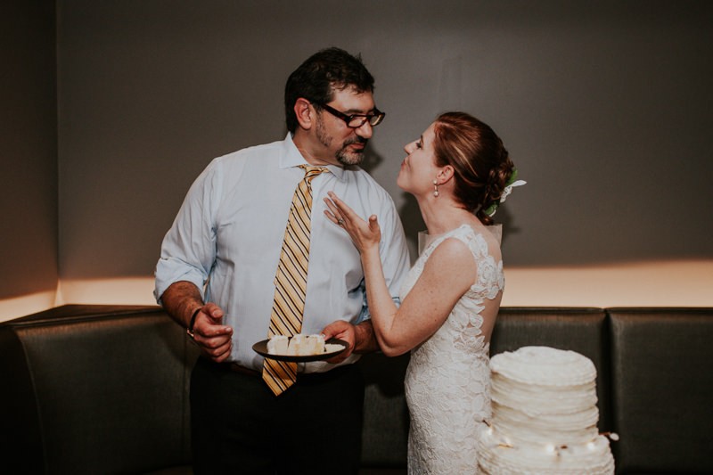 Bride and groom go in for a kiss after they cut the cake.