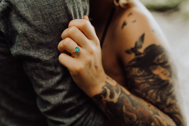 Blue Moissanite engagement ring on a tattooed bride. 